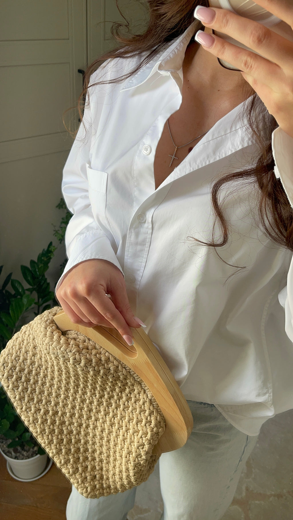 Sand – handvirkad beige clutch, buren i handen